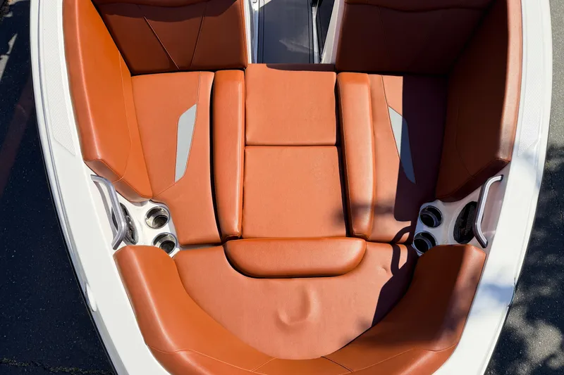 Slide: The Image of 2023 MasterCraft NXT23 boat interior with brown leather seating and cup holders. - 20