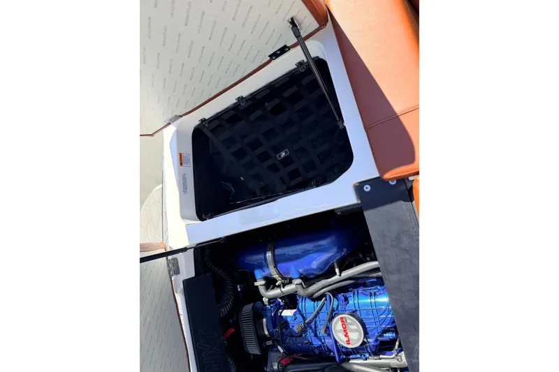 Slide: The Image of 2023 MasterCraft NXT23 boat engine compartment with open hatch and visible components. - 24