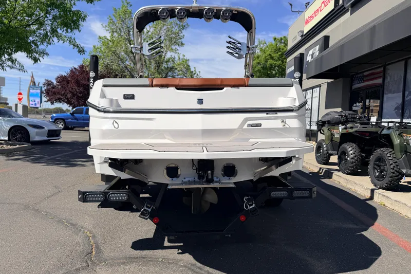 Slide: The Image of 2023 MasterCraft NXT23 boat rear view at dealership, showcasing sleek design and features. - 5