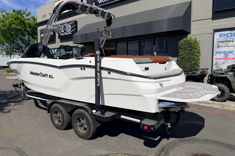 Slide: The Image of 2023 MasterCraft NXT23 boat on trailer, parked outside dealership, showcasing sleek design. - 6