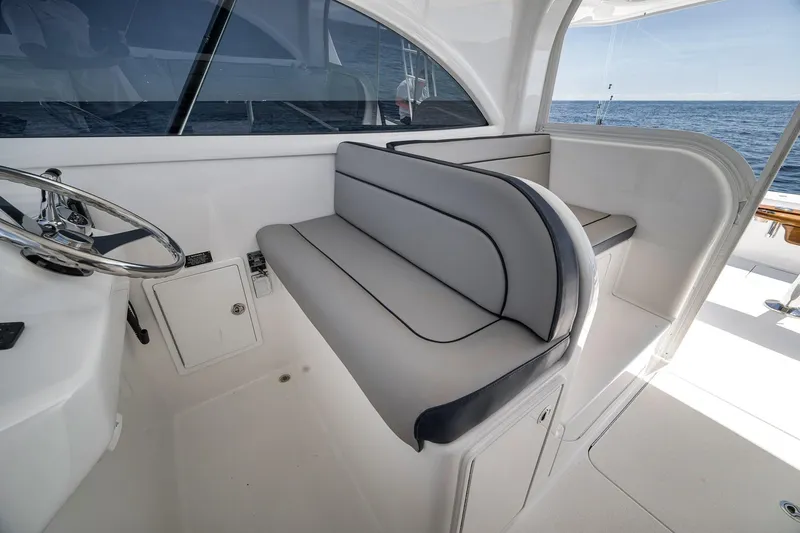 Slide: The Image of 2018 Viking 37 Billfish helm area with cushioned seating and steering wheel, overlooking the ocean. - 36