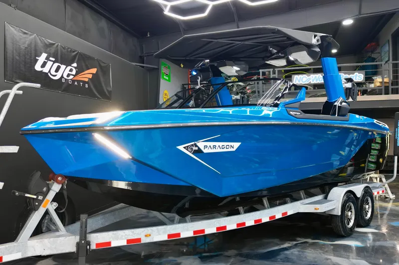 Slide: The Image of 2022 Nautique Super Air Nautique G25 Paragon in showroom, vibrant blue on trailer. - 22