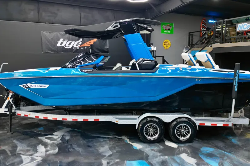 Slide: The Image of 2022 Nautique Super Air Nautique G25 Paragon boat in showroom, vibrant blue color. - 3
