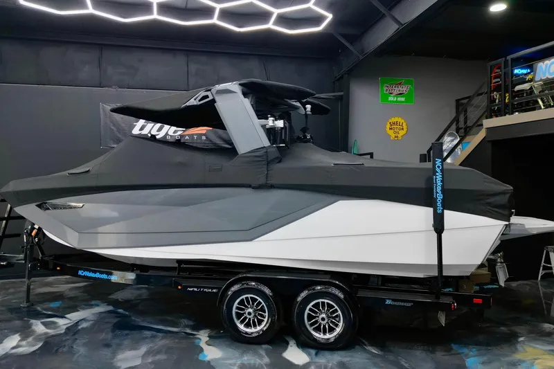 Slide: The Image of 2024 Nautique Super Air Nautique G23 boat covered in a showroom with modern lighting. - 20