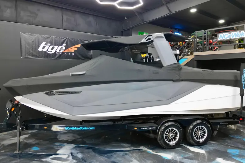 Slide: The Image of 2024 Nautique Super Air Nautique G23 boat covered on trailer in showroom. - 21