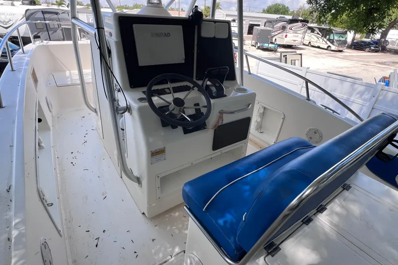 Slide: The Image of 1999 World Cat 246 SF boat interior with steering console and blue seating. - 10
