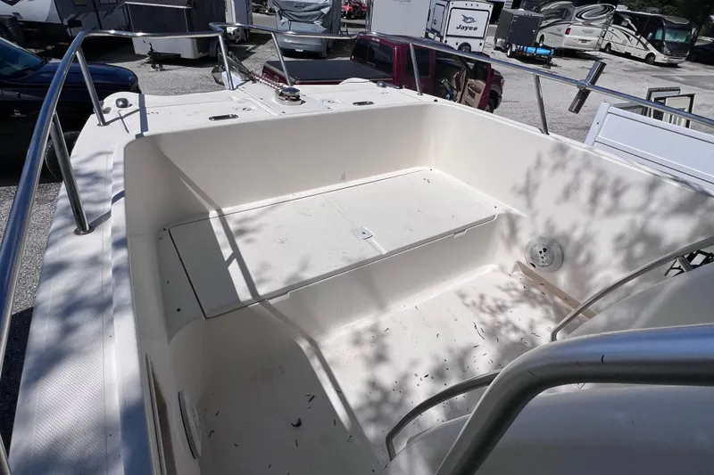 Slide: The Image of 1999 World Cat 246 SF boat interior with seating and railing, parked in a lot. - 13
