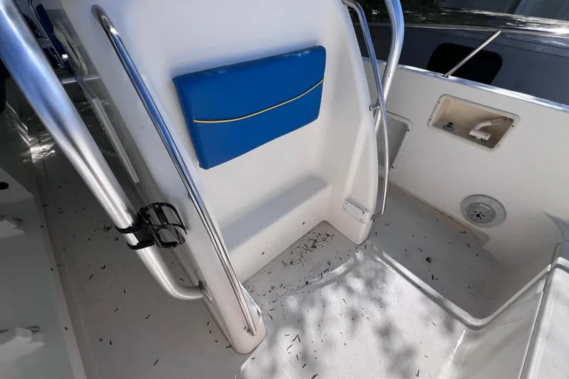 Slide: The Image of Interior of a 1999 World Cat 246 SF boat, featuring blue seating and stainless steel railings. - 16