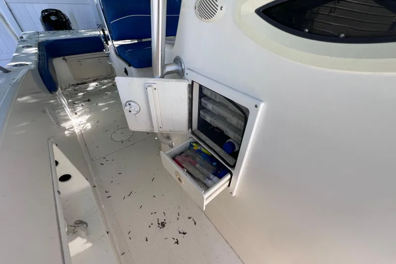 Slide: The Image of 1999 World Cat 246 SF boat interior with open storage compartments and blue seating. - 17