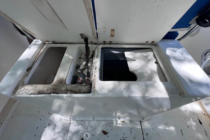 Slide: The Image of Open compartments on a 1999 World Cat 246 SF boat, showing interior storage space. - 19
