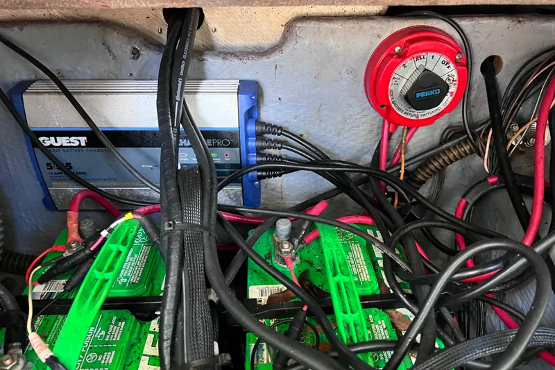 Slide: The Image of Battery compartment of a 1999 World Cat 246 SF with charger and wiring. - 21