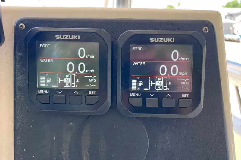 Slide: The Image of Suzuki digital gauges on a 1999 World Cat 246 SF boat dashboard. - 23