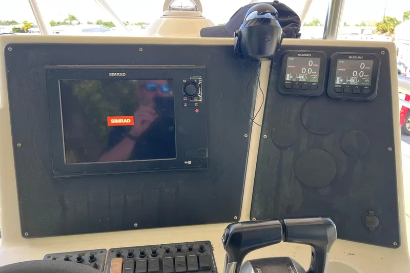 Slide: The Image of Control panel of a 1999 World Cat 246 SF boat with Simrad display and Suzuki gauges. - 24