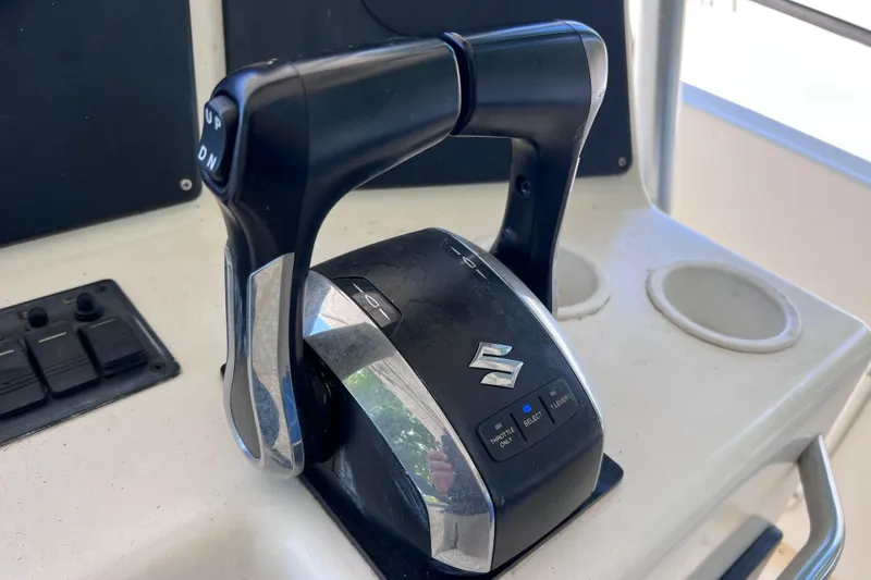 Slide: The Image of Throttle control of a 1999 World Cat 246 SF boat with Suzuki branding. - 27