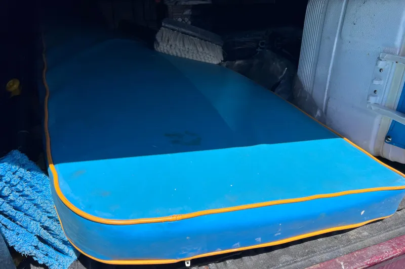 Slide: The Image of Blue boat cushion on a 1999 World Cat 246 SF, stored with marine equipment. - 32