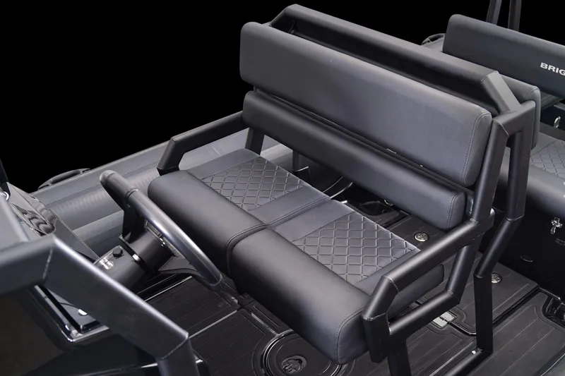 Slide: The Image of 2026 Brig Navigator 20 boat interior with black cushioned seating and steering wheel. - 11