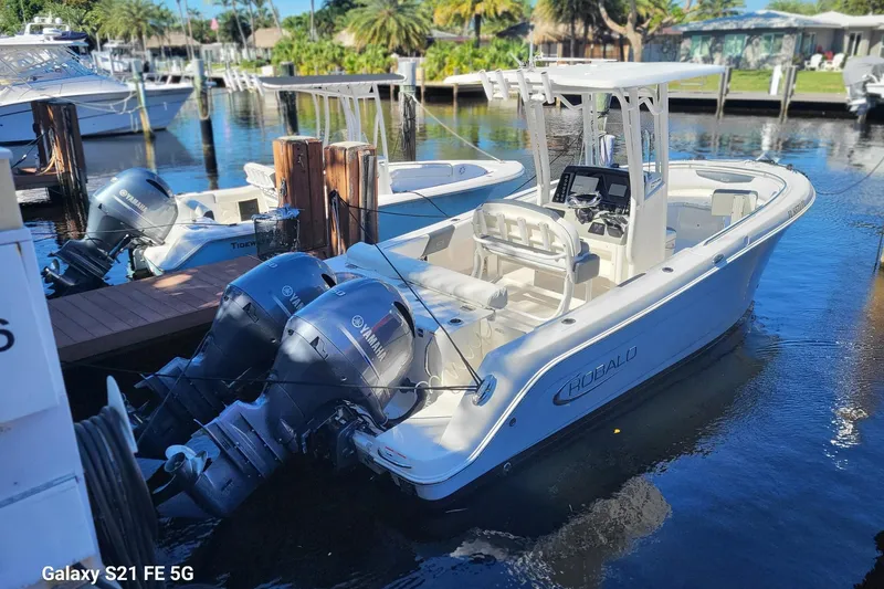 Slide: The Image of 2019 Robalo R242 Center Console boat docked with dual Yamaha engines. - 2