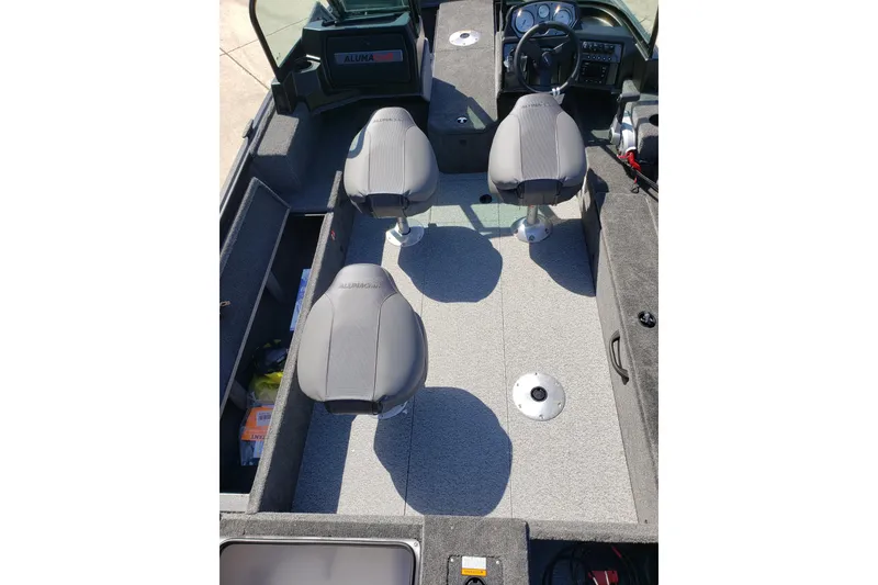 Slide: The Image of 2026 Alumacraft Voyageur 175 Sport interior with three seats and steering console. - 22