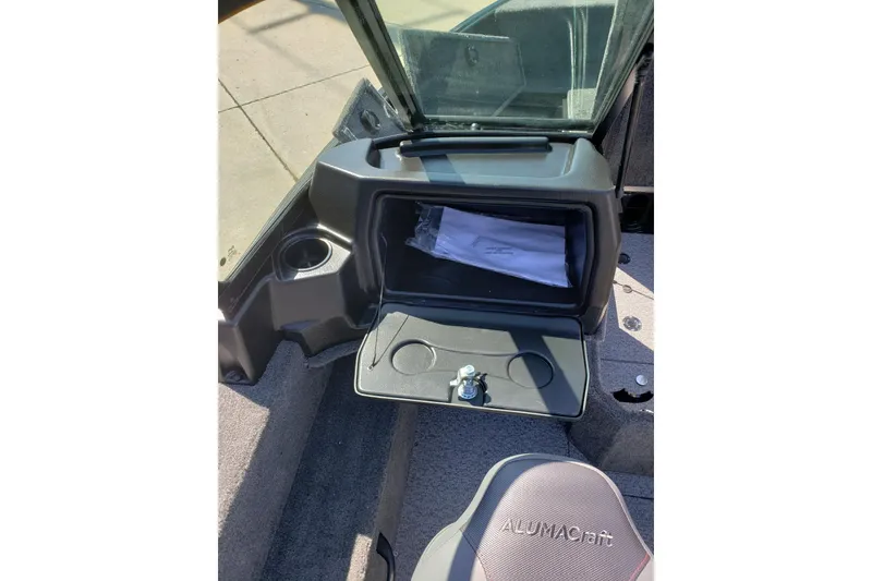 Slide: The Image of 2026 Alumacraft Voyageur 175 Sport boat interior with storage compartment and cup holder. - 26