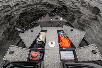 Slide: The Image of 2026 Alumacraft Voyageur 175 Sport boat with open storage compartments on water. - 7