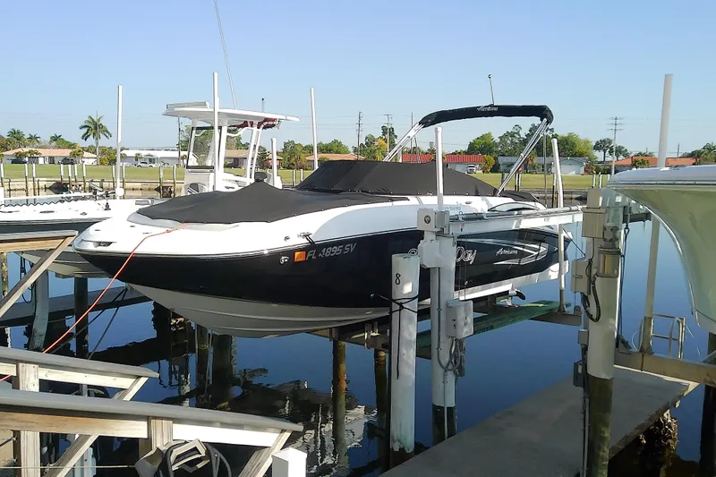 The Image of 2021 Hurricane SunDeck 2410 OB boat docked on a lift in a marina. - 0
