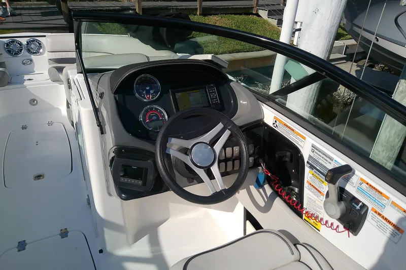 Slide: The Image of 2021 Hurricane SunDeck 2410 OB boat cockpit with steering wheel and control panel. - 14