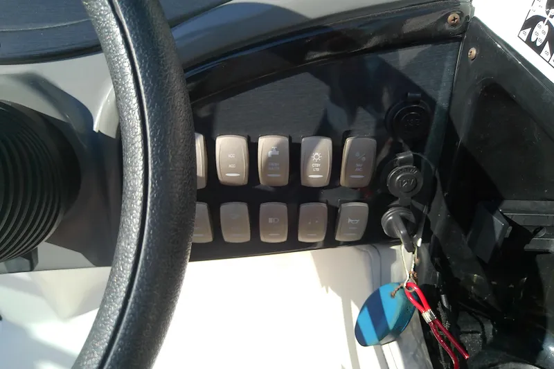 Slide: The Image of Control panel of a 2021 Hurricane SunDeck 2410 OB boat with switches and key. - 18