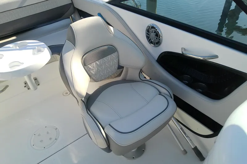 Slide: The Image of 2021 Hurricane SunDeck 2410 OB boat interior with cushioned seating and cup holders. - 19