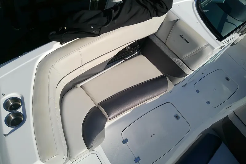 Slide: The Image of 2021 Hurricane SunDeck 2410 OB boat interior with cushioned seating and cup holders. - 6