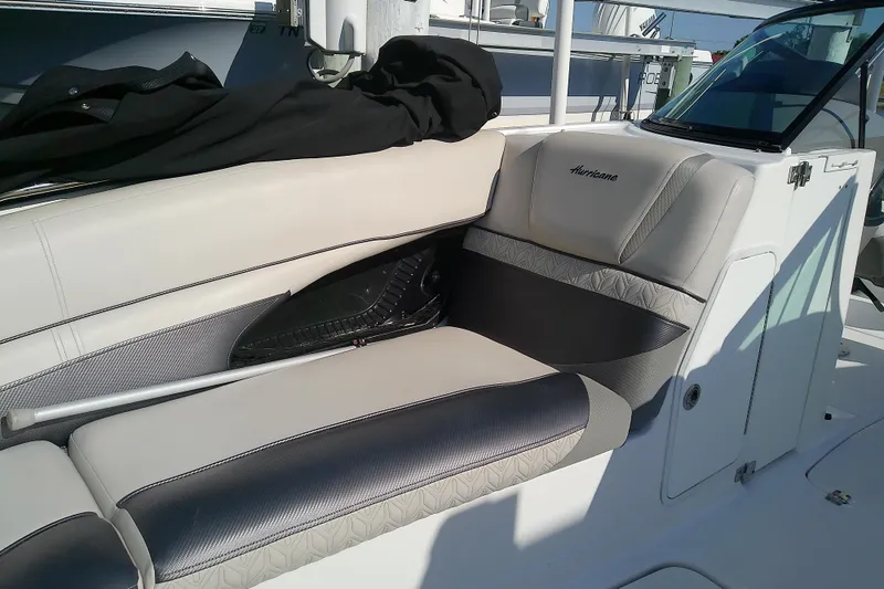 Slide: The Image of 2021 Hurricane SunDeck 2410 OB boat interior with cushioned seating and storage compartment. - 8