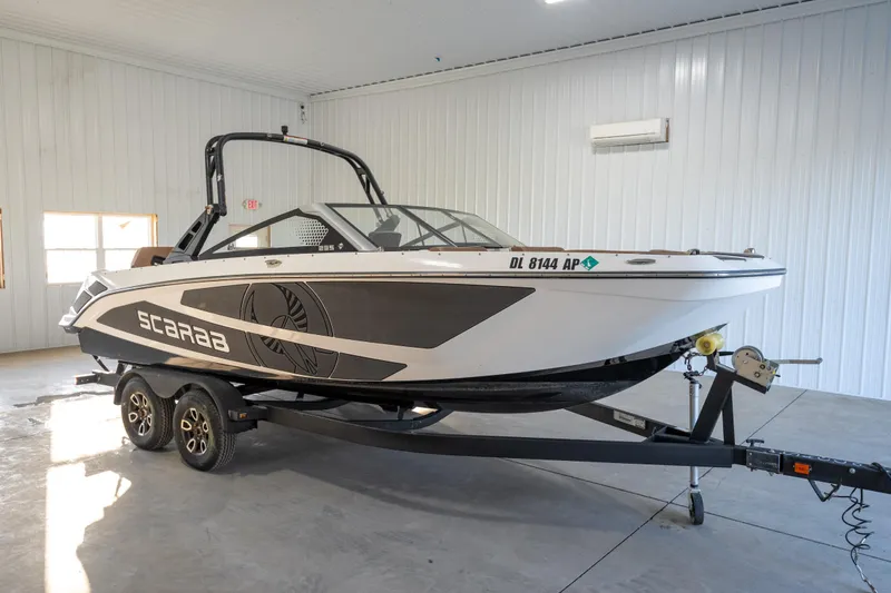 The Image of 2024 Scarab 235 ID boat on trailer in a spacious indoor setting. - 0