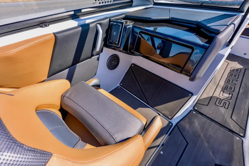 Slide: The Image of 2024 Scarab 235 ID boat interior with tan and black seating, modern dashboard. - 4