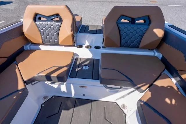 Slide: The Image of 2024 Scarab 235 ID boat interior with tan and black seating, modern dashboard, and Scarab branding. - 9