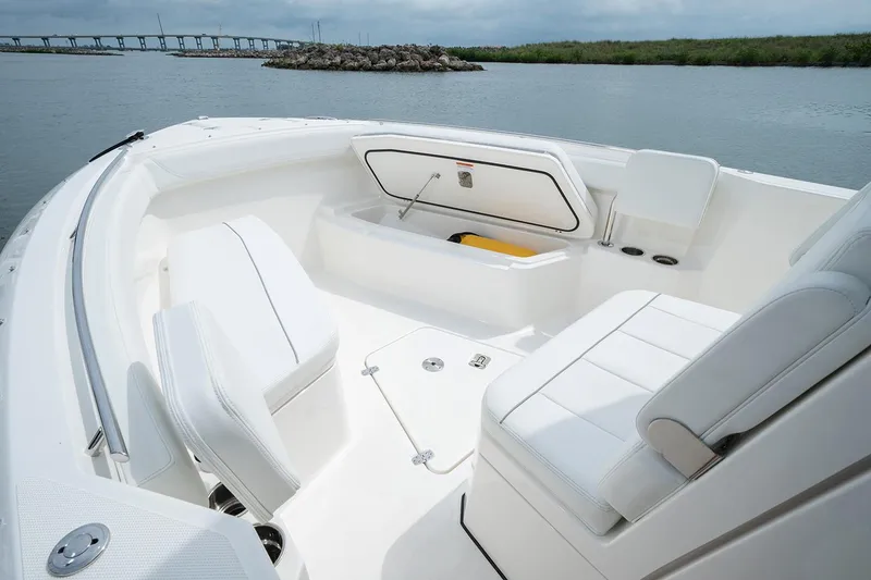 Slide: The Image of Manufacturer Provided Image: 2022 Pursuit S 268 Sport boat interior with white seating and storage compartment. - 10