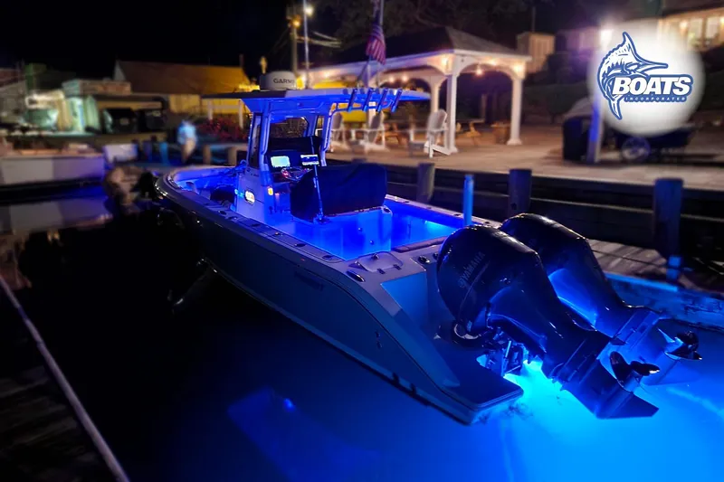 Slide: The Image of 2022 Pursuit S 268 Sport boat illuminated with blue lights at night dockside. - 22