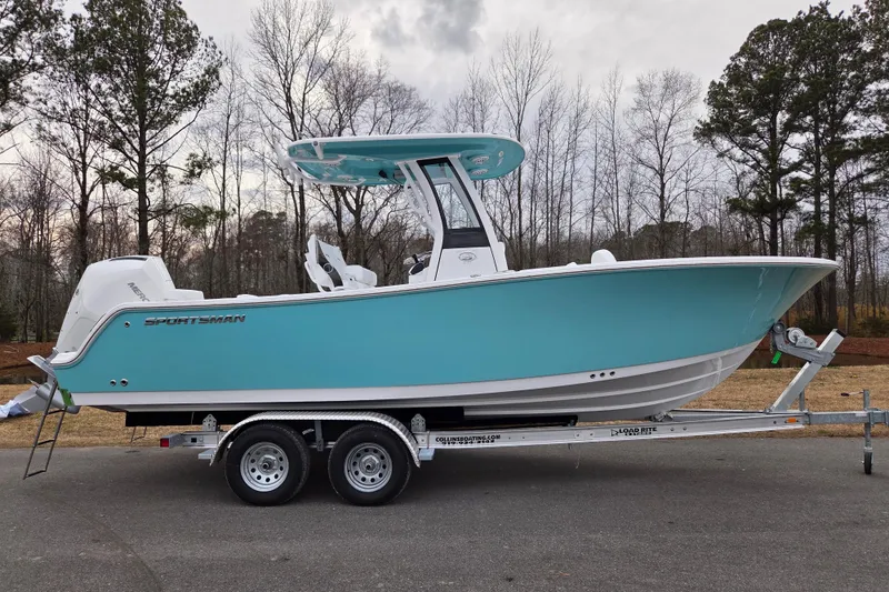 The Image of 2026 Sportsman Heritage 231 Center Console boat on trailer, parked outdoors. - 0