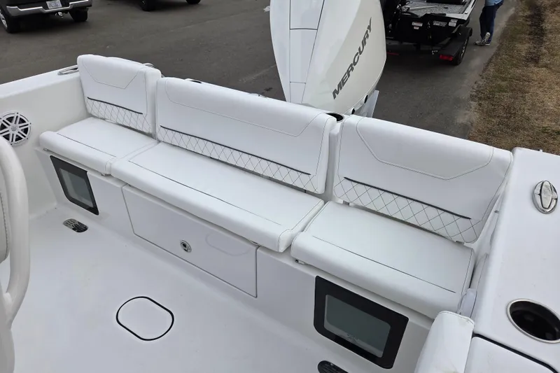 Slide: The Image of 2026 Sportsman Heritage 231 Center Console boat with white cushioned seating and Mercury engine. - 11