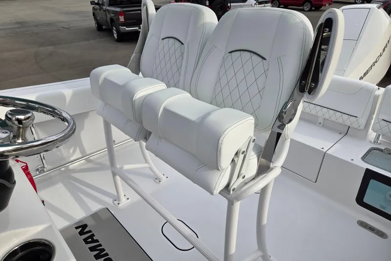 Slide: The Image of 2026 Sportsman Heritage 231 Center Console boat with white cushioned seating and steering wheel. - 12