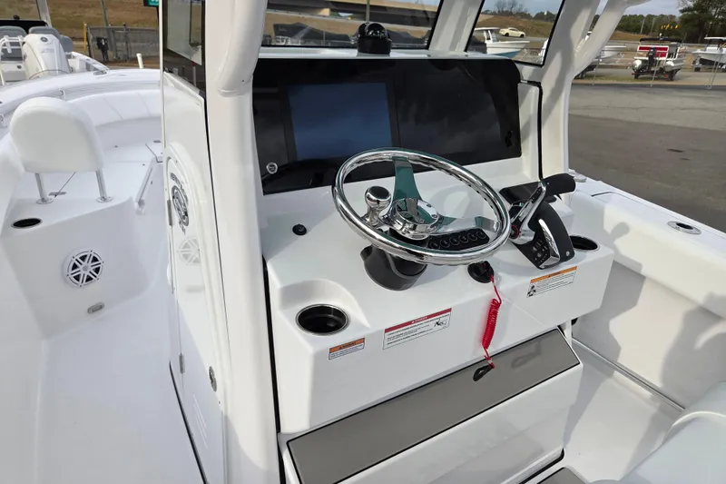 Slide: The Image of 2026 Sportsman Heritage 231 Center Console boat dashboard with steering wheel and controls. - 13