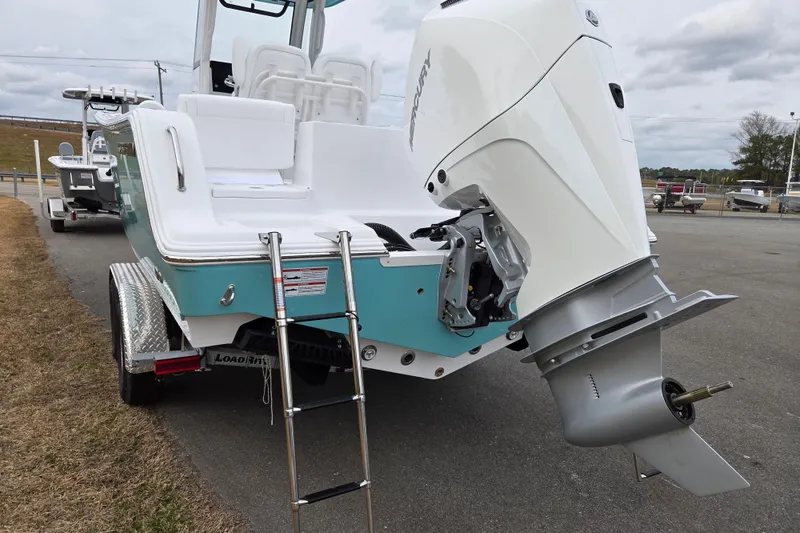 Slide: The Image of 2026 Sportsman Heritage 231 Center Console boat with Mercury outboard motor and ladder. - 4