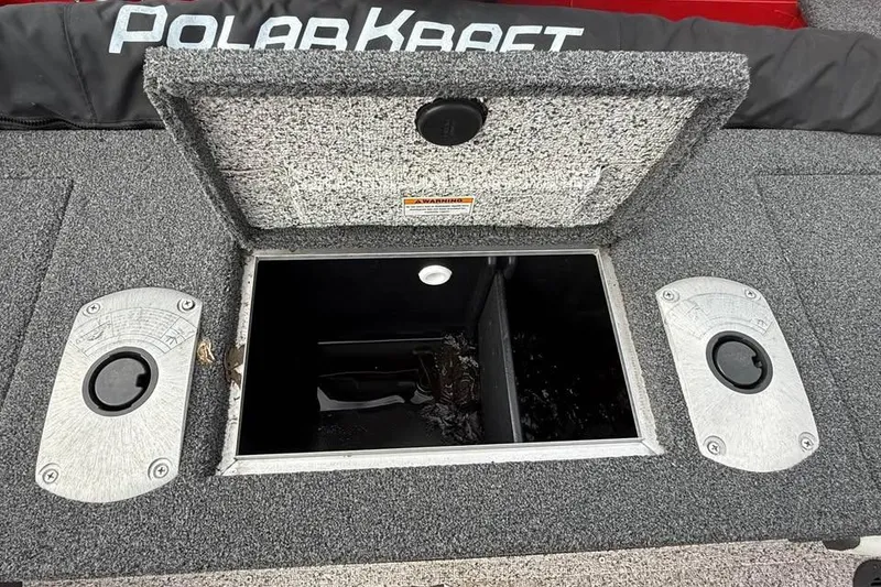Slide: The Image of 2023 Polar Kraft Frontier 179 WT boat storage compartment with open hatch and carpeted surface. - 11