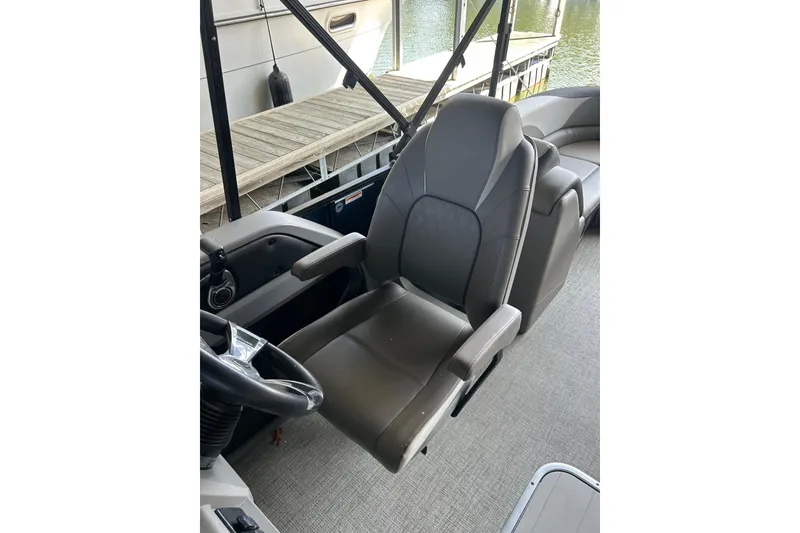 Slide: The Image of Captain's chair on 2022 Avalon 2485 LSZ QL pontoon boat, docked by water. - 5
