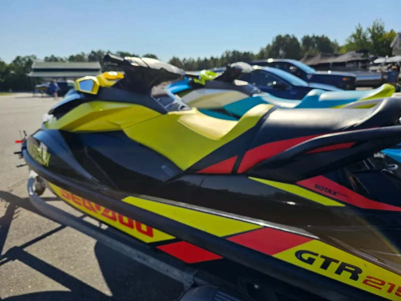 Slide: The Image of 2015 Sea-Doo GTR 215 jet ski in vibrant colors on a parking lot. - 3