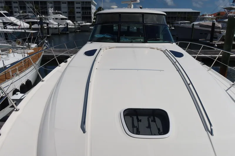 Slide: The Image of 2005 Sea Ray 500 Sundancer yacht docked at marina, showcasing sleek deck design. - 13