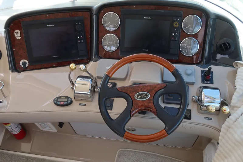 Slide: The Image of Cockpit of 2005 Sea Ray 500 Sundancer with steering wheel and navigation controls. - 4