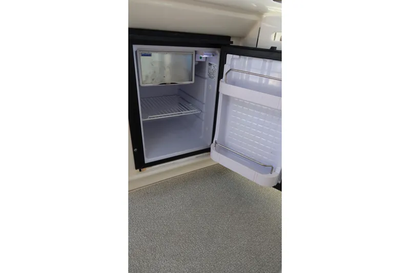 Slide: The Image of Open mini fridge inside 2005 Sea Ray 500 Sundancer yacht, showing interior shelves. - 6