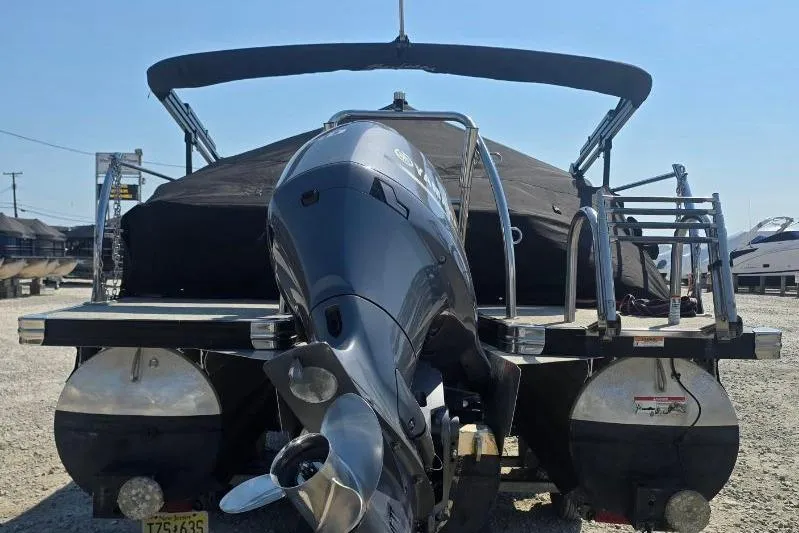 Slide: The Image of 2022 Barletta C22UC pontoon boat with outboard motor, covered and docked. - 2