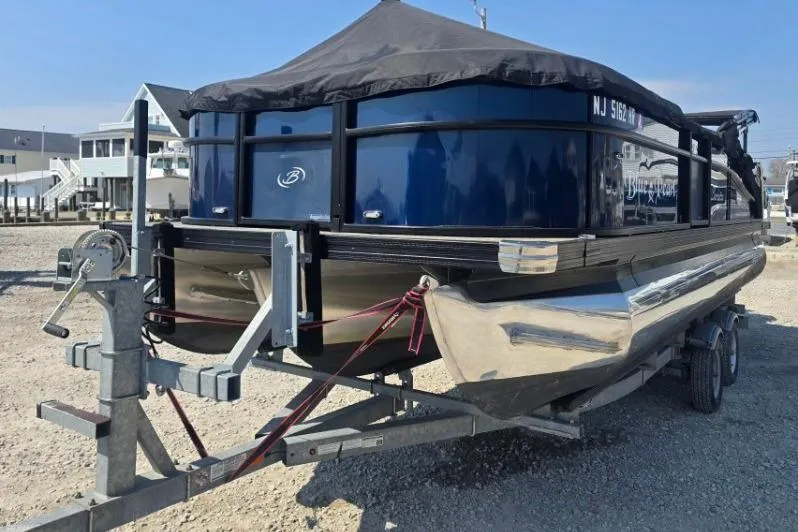 Slide: The Image of 2022 Barletta C22UC pontoon boat on trailer, covered and parked outdoors. - 3