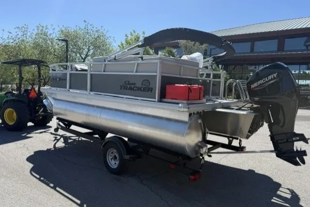 Slide: The Image of 2026 Sun Tracker Bass Buggy 16 XL Select pontoon boat on trailer with Mercury outboard motor. - 11