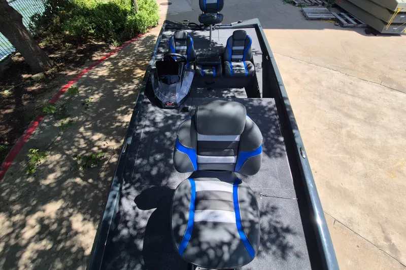 Slide: The Image of 2026 Ranger RT188 boat interior with blue and gray seating, parked outdoors. - 7